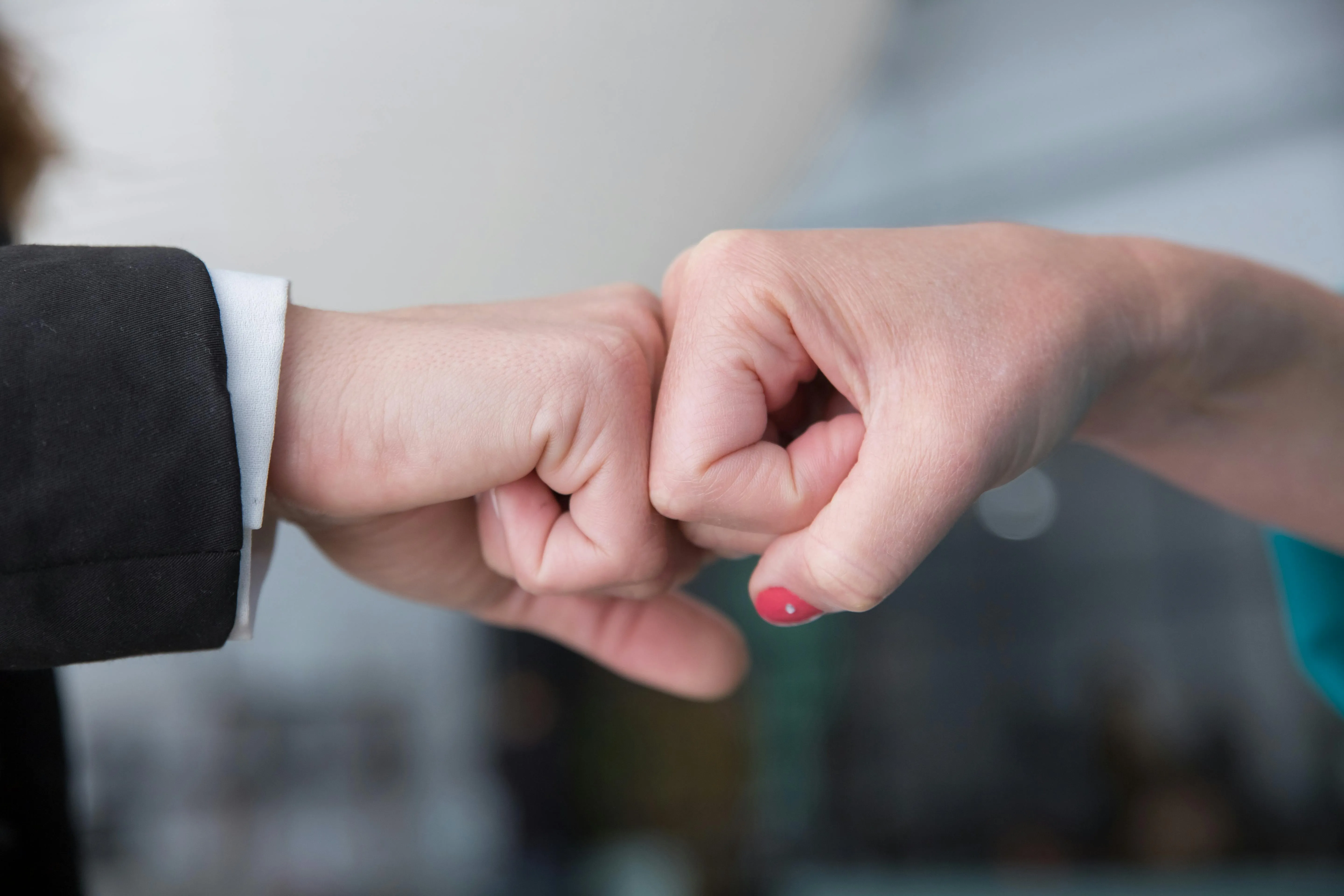 Duas pessoas se cumprimentam com um toque de punhos.