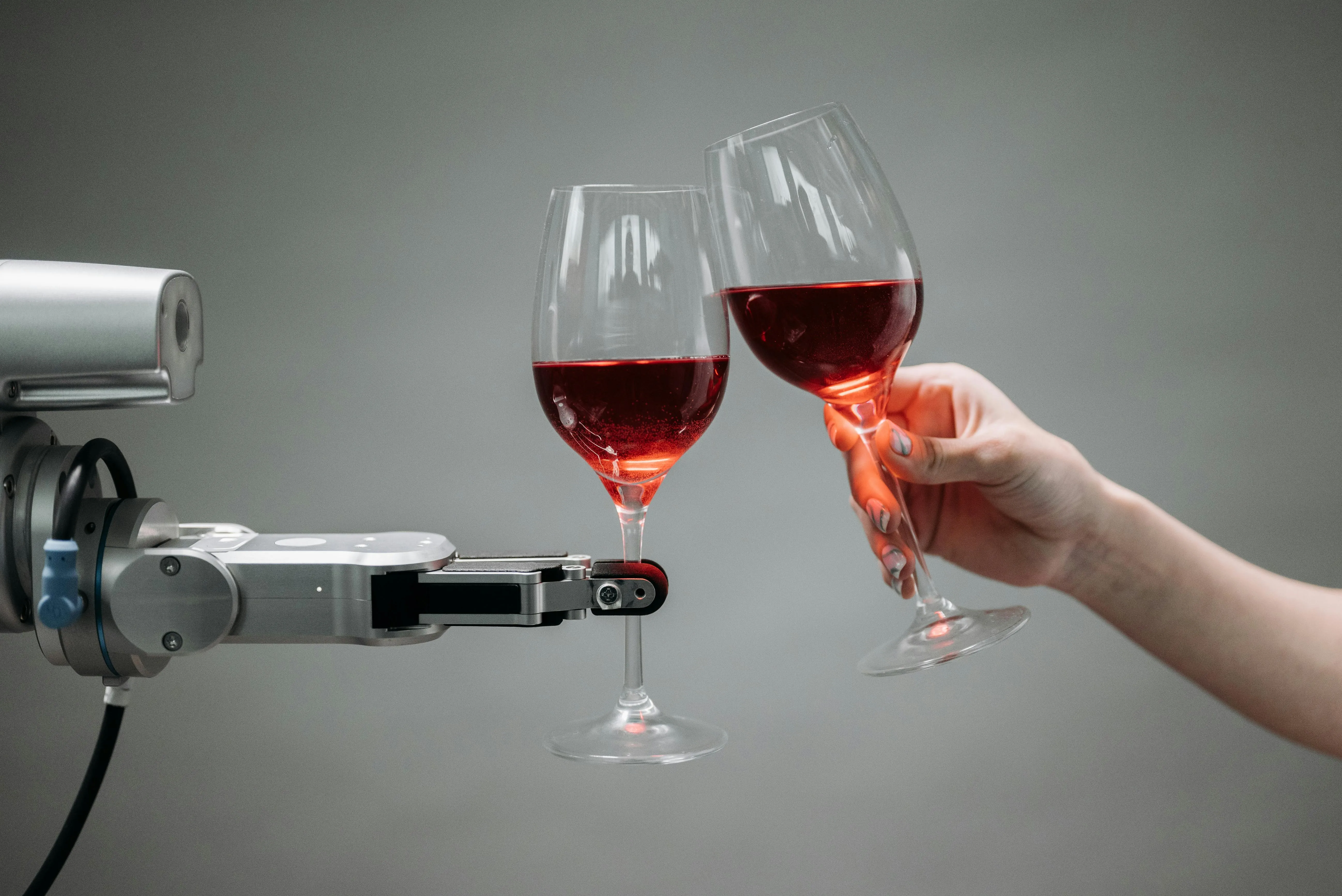 Robô serve taças de vinho tinto, simbolizando automação e IA na gastronomia.