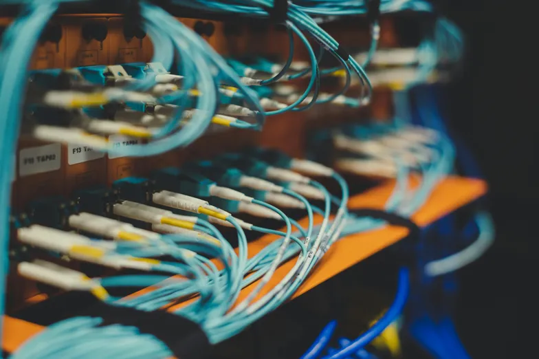 Cabos de fibra óptica conectados em painel de rede de servidor