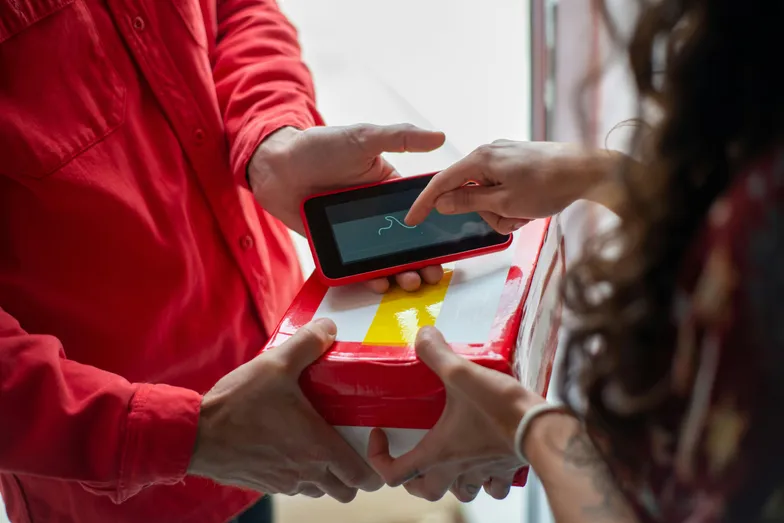 Cliente assinando entrega em dispositivo eletrônico