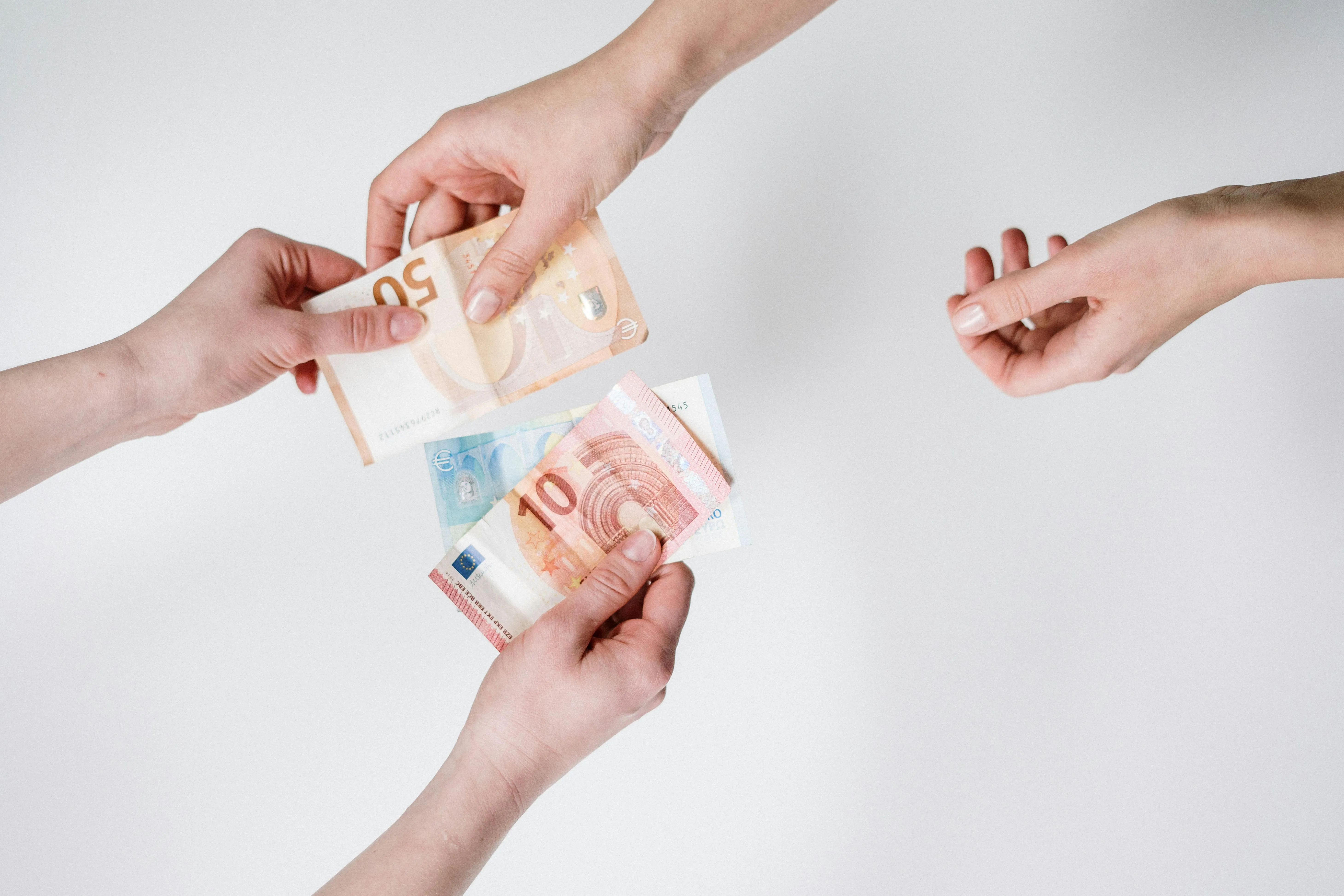 Mãos trocando notas de euro em fundo branco
